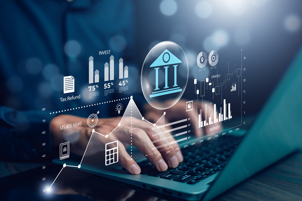Man typing on laptop with finance and investments showing above laptop. Concept for industries benefitting from colocation.